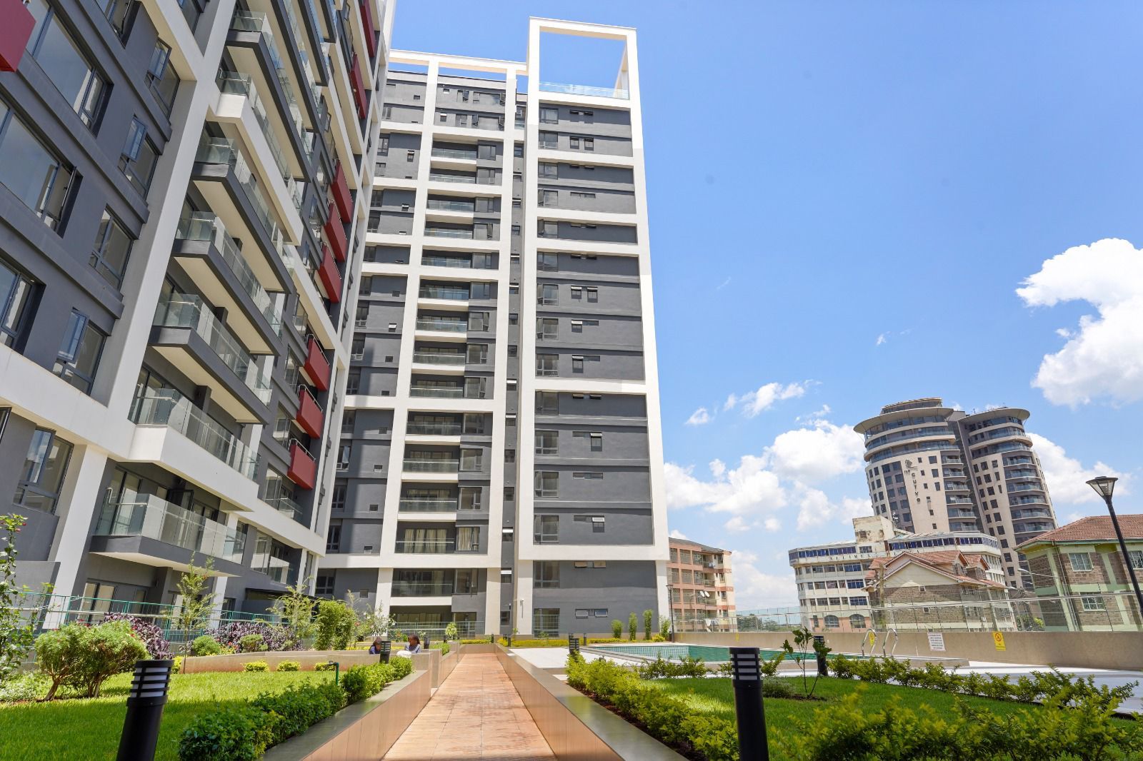 Modern apartment towers with landscaped gardens, a walkway and a pool in Nairobi