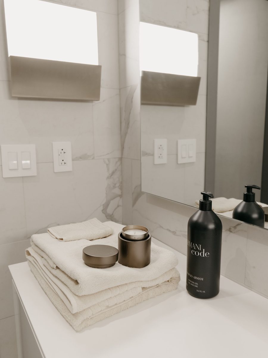 Folded white towels and toiletries on a marble vanity
