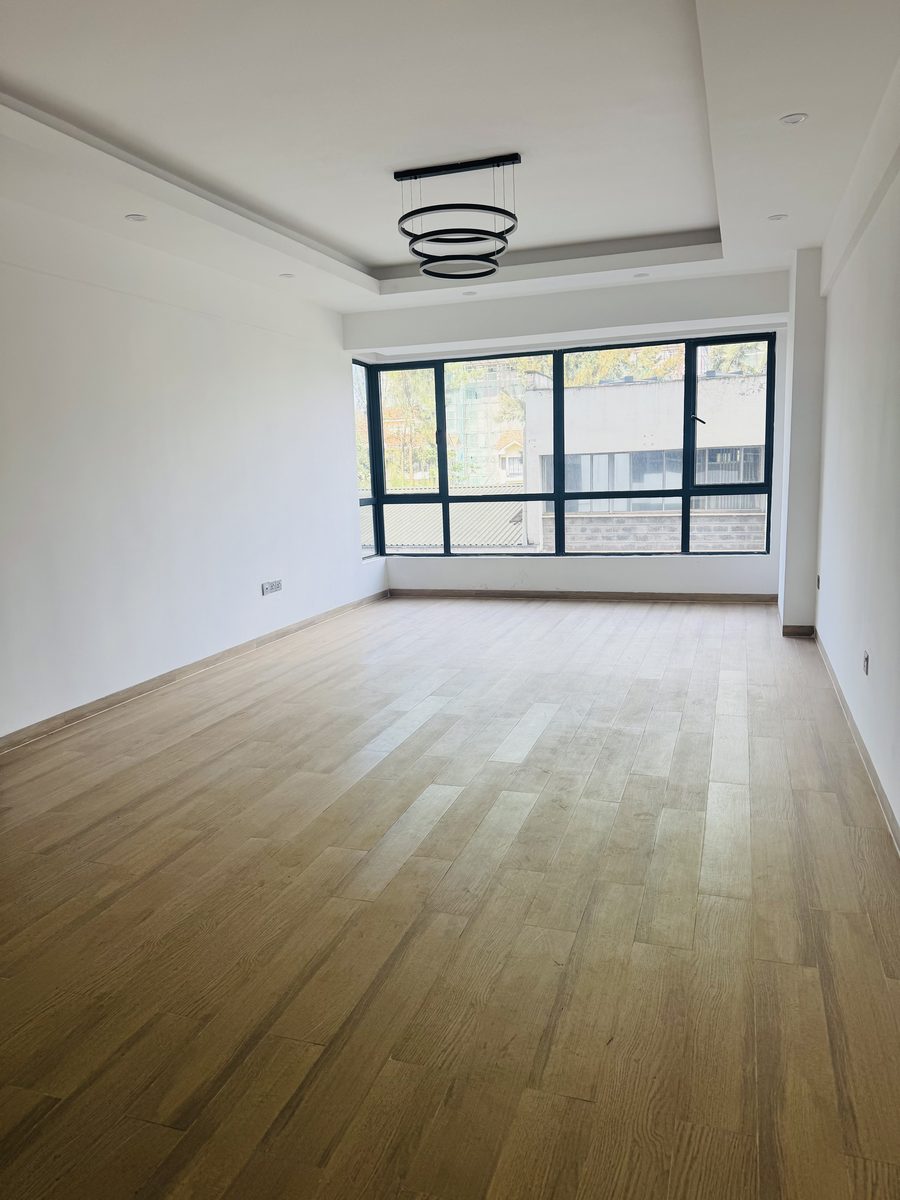 Empty living room with wood floors and black-framed windows